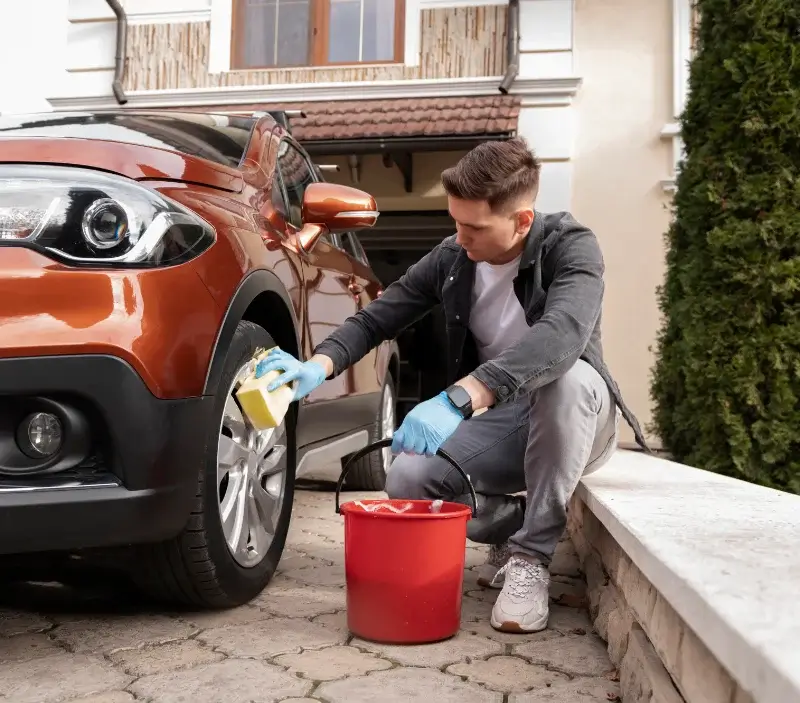 Lavage auto à domicile Saint-Malo-de-la-Lande : professionnel intervenant sur un véhicule